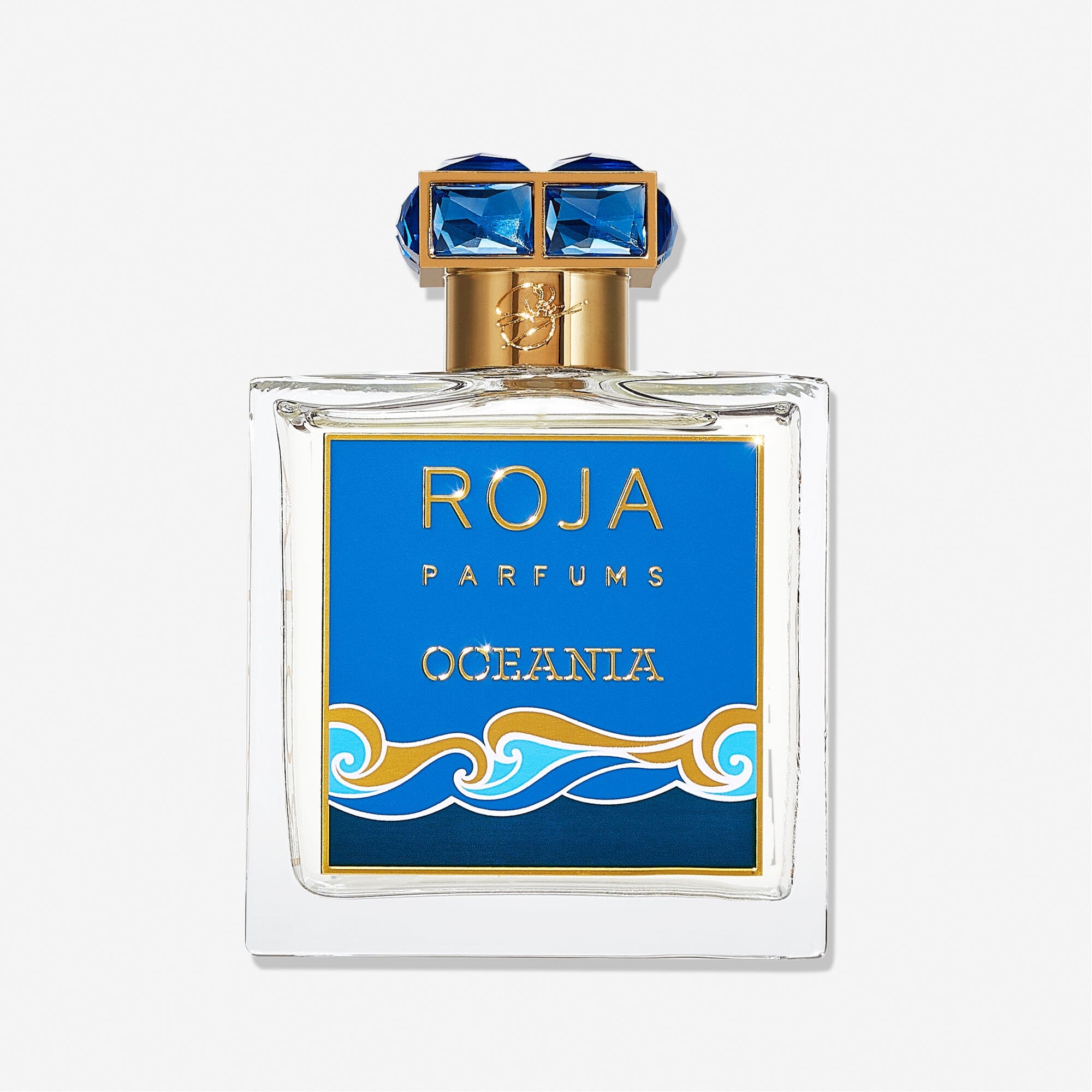 A square glass bottle of Roja Parfums Oceania features a blue and gold label with ocean wave graphics, topped with a gold cap adorned with blue accents, reflecting the fragranceâ€™s fresh citrus character.